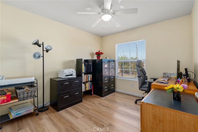 office area with baseboards, light wood-style floors, and ceiling fan