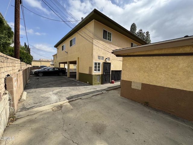 view of side of property featuring fence and stucco siding