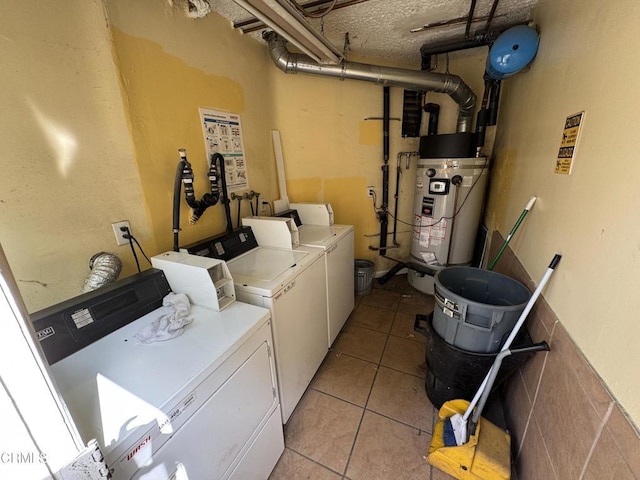 laundry area with light tile patterned flooring, water heater, and washer and clothes dryer