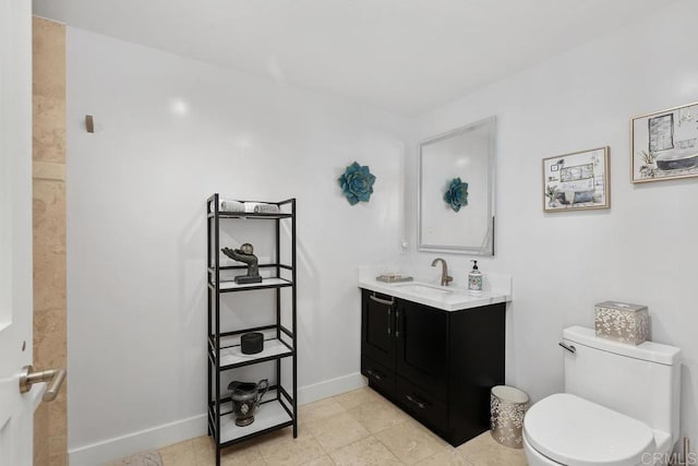 bathroom with vanity, toilet, baseboards, and tile patterned flooring