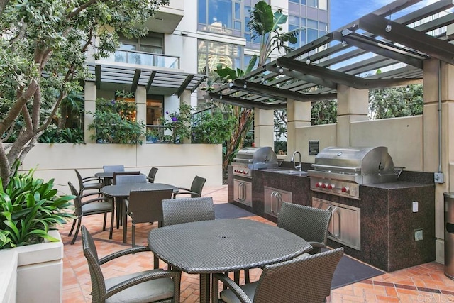 view of patio / terrace featuring a sink, area for grilling, outdoor dining space, and a pergola