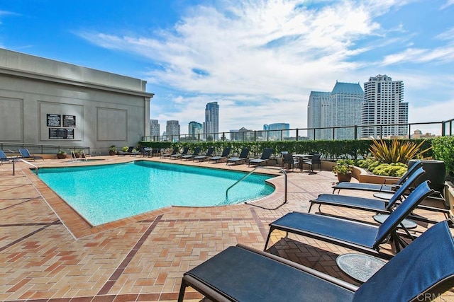 pool with a view of city and a patio area