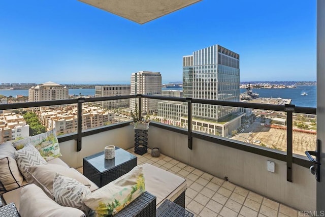 balcony with a city view, an outdoor living space, and a water view