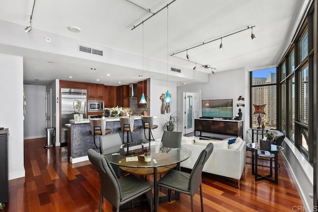 dining area featuring visible vents, dark wood-style flooring, and baseboards