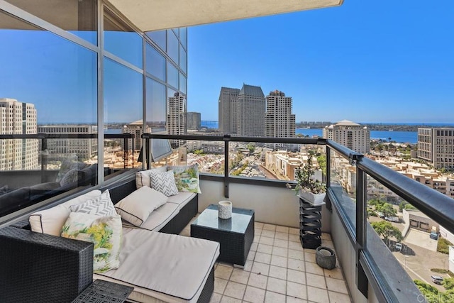 balcony featuring an outdoor living space, a view of city, and a water view