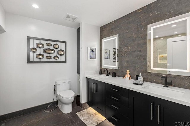 bathroom featuring a sink, visible vents, toilet, and decorative backsplash