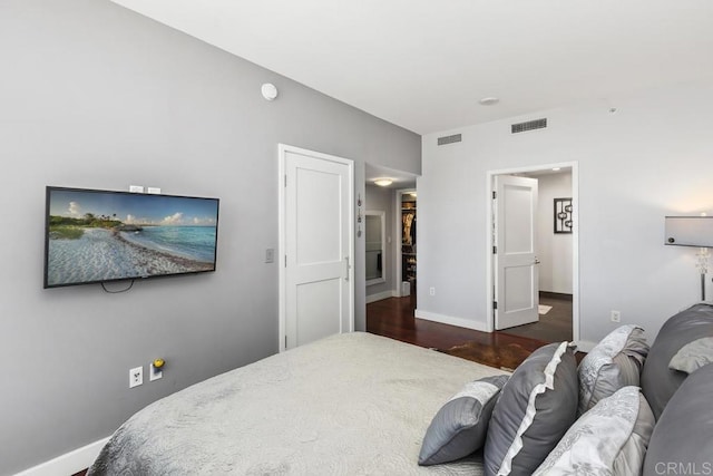 bedroom with visible vents, baseboards, and wood finished floors