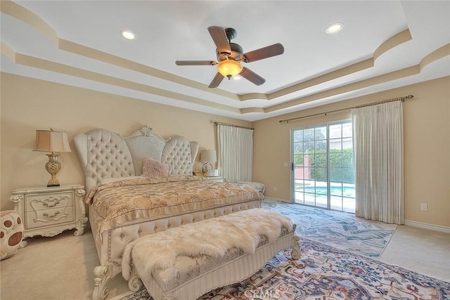 bedroom featuring access to exterior, ceiling fan, baseboards, light carpet, and a raised ceiling