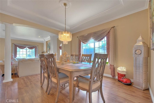 dining room featuring baseboards, light wood-style floors, and crown molding