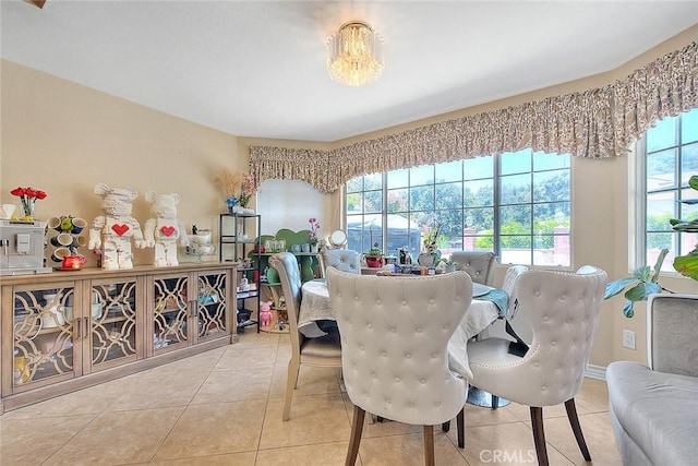 tiled dining space featuring a healthy amount of sunlight and baseboards