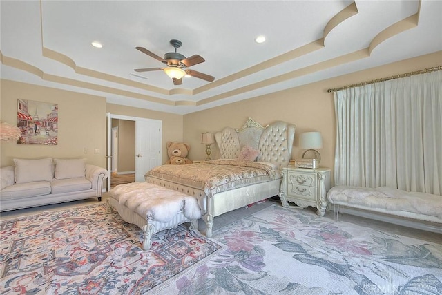 bedroom featuring recessed lighting, a raised ceiling, and a ceiling fan