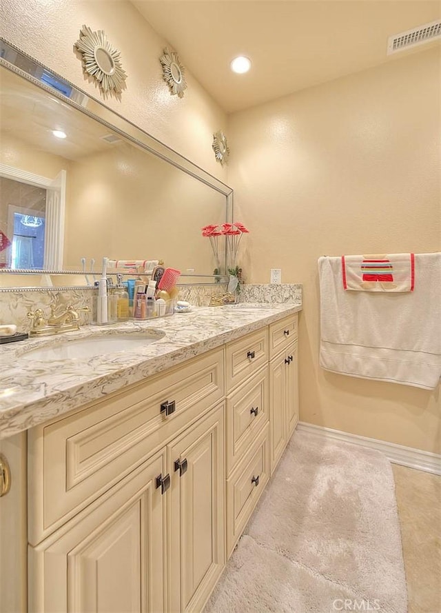 full bathroom with baseboards, visible vents, double vanity, recessed lighting, and a sink