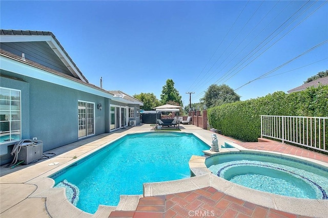 view of swimming pool featuring a patio area, a fenced backyard, and a pool with connected hot tub