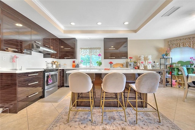 kitchen featuring visible vents, stainless steel electric stove, a kitchen bar, a raised ceiling, and modern cabinets