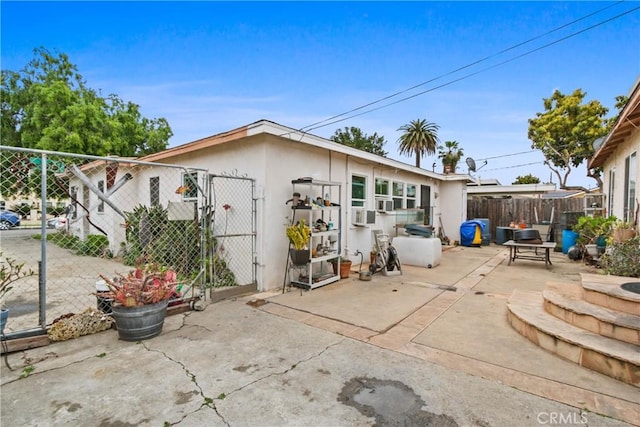 back of house with a gate, a patio area, stucco siding, and fence