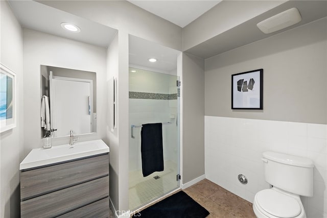 bathroom featuring vanity, recessed lighting, a shower stall, tile walls, and toilet