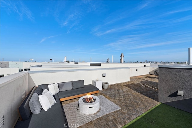 view of patio / terrace featuring an outdoor living space with a fire pit and a balcony