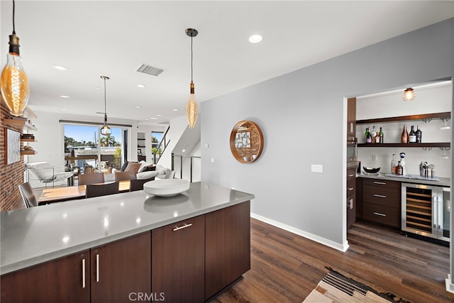 kitchen featuring dark wood-style floors, beverage cooler, visible vents, dark brown cabinets, and open floor plan