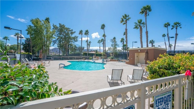 pool with a patio and fence