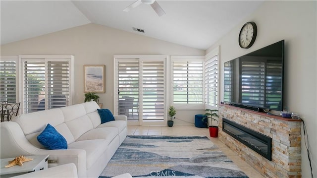 tiled living area featuring visible vents, ceiling fan, a fireplace, and lofted ceiling