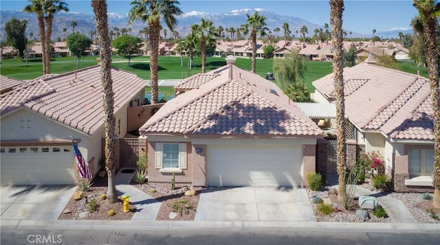 view of front of house with a tiled roof, a residential view, an attached garage, and driveway