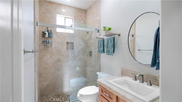 full bathroom with vanity, a shower stall, and toilet