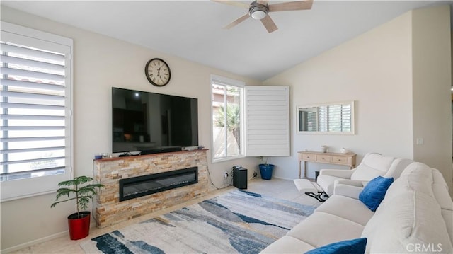 tiled living room featuring baseboards, lofted ceiling, a fireplace, and a ceiling fan