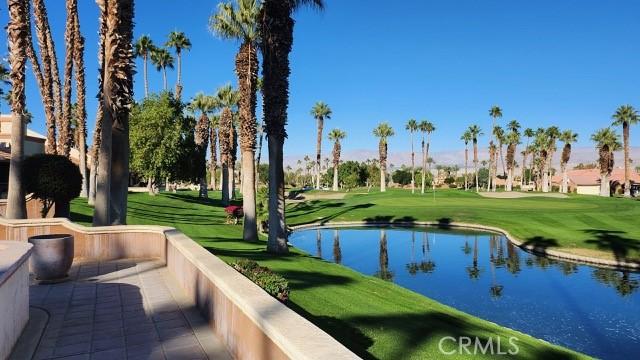 view of community featuring a water view, a lawn, and view of golf course