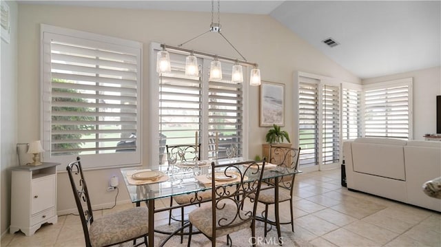 dining space with light tile patterned flooring, visible vents, and lofted ceiling