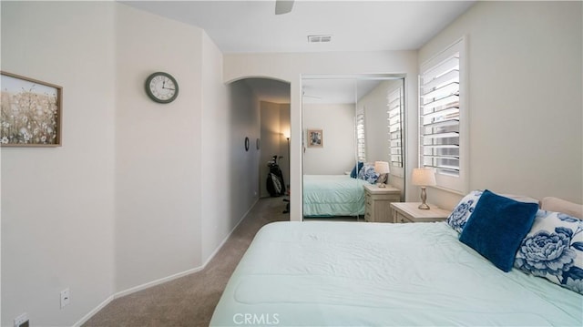 bedroom with visible vents, arched walkways, baseboards, and carpet flooring