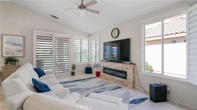 tiled living area with a fireplace, lofted ceiling, a ceiling fan, and visible vents