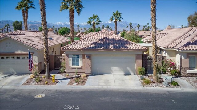 view of front of home featuring a tiled roof, a garage, driveway, and stucco siding