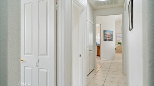 corridor featuring light tile patterned floors and visible vents
