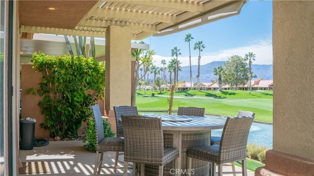 view of patio / terrace featuring outdoor dining space, a mountain view, and a pergola