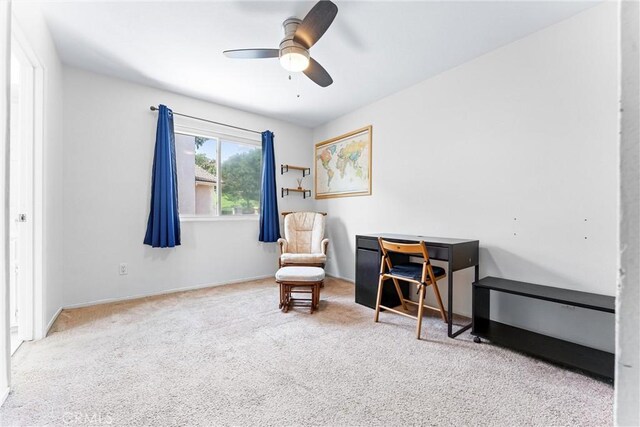 living area featuring a ceiling fan, baseboards, and carpet floors