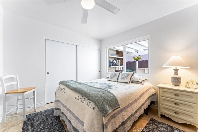 bedroom featuring a closet, a ceiling fan, and light tile patterned flooring