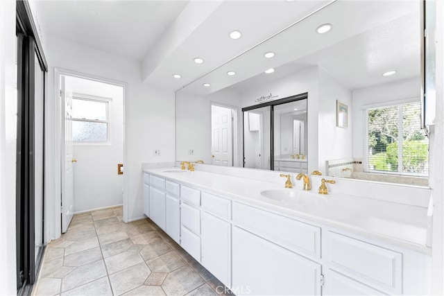 full bath with a sink, a wealth of natural light, and double vanity