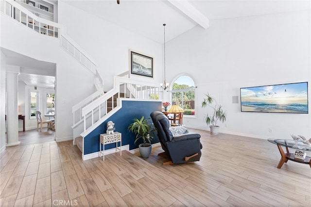 living room with beam ceiling, stairway, wood finished floors, and high vaulted ceiling