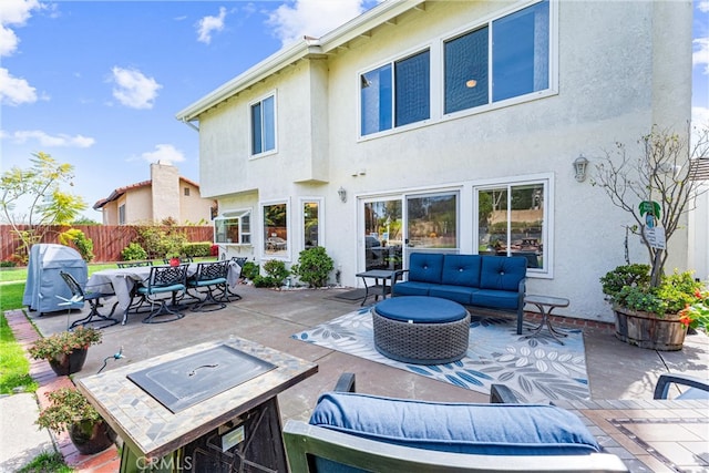 rear view of property featuring stucco siding, fence, outdoor dining area, an outdoor hangout area, and a patio area