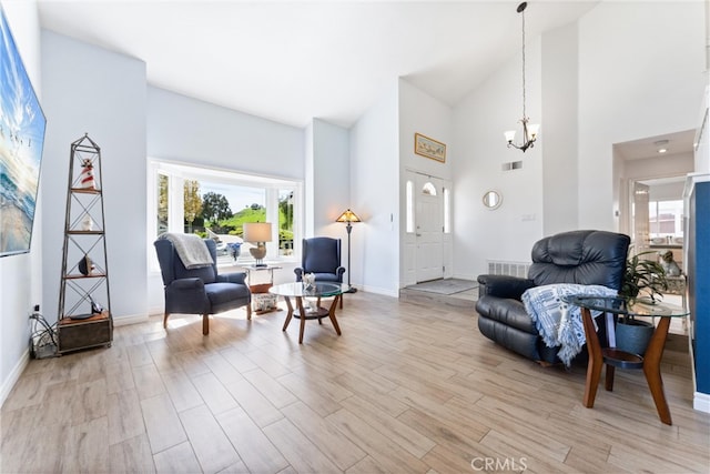 living area with a notable chandelier, visible vents, light wood-type flooring, and baseboards