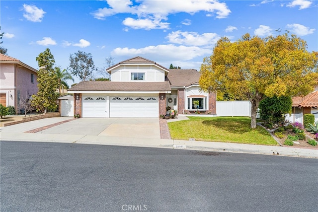 traditional-style house with an attached garage, concrete driveway, a front lawn, and fence