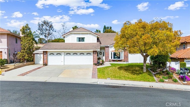 traditional-style home featuring a front lawn, fence, concrete driveway, an attached garage, and a tiled roof