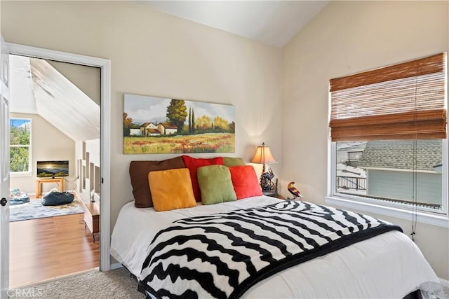 bedroom with lofted ceiling and wood finished floors