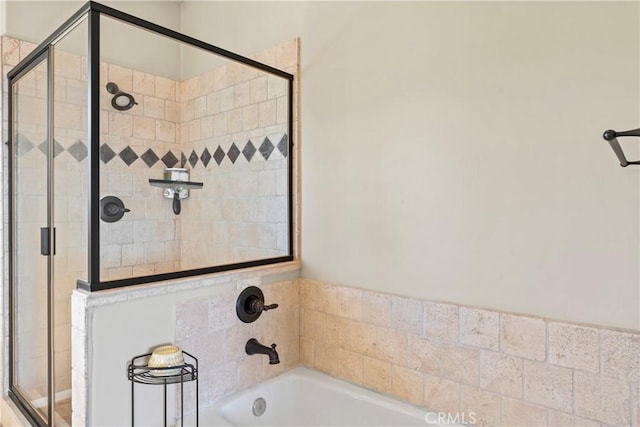 full bathroom featuring a bath and a shower stall