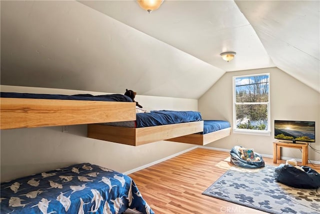 bedroom featuring vaulted ceiling, baseboards, and wood finished floors