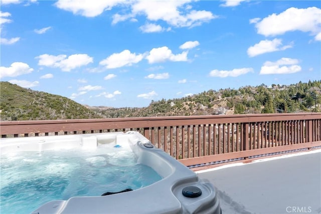 view of swimming pool featuring a deck and a hot tub