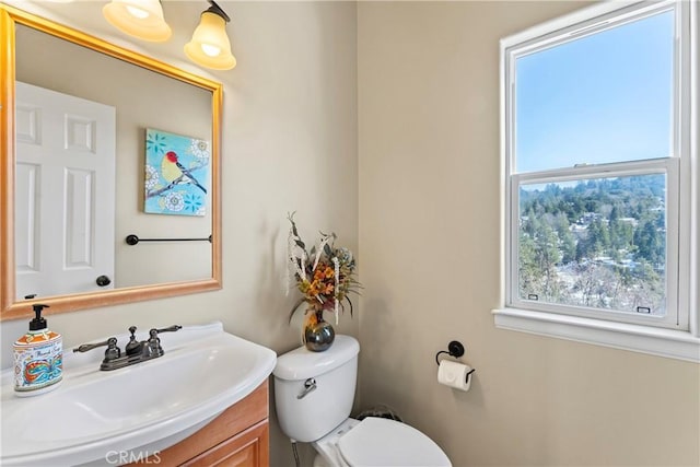 half bathroom with vanity and toilet