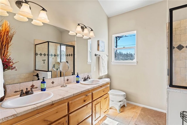 bathroom featuring double vanity, a shower stall, baseboards, and a sink