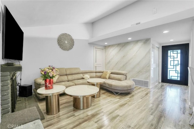 living area featuring lofted ceiling, recessed lighting, wood finished floors, and visible vents