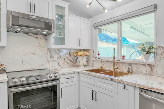 kitchen featuring a sink, light countertops, white cabinets, appliances with stainless steel finishes, and backsplash